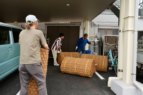 ロール状のココペーバーを運ぶ施工の様子