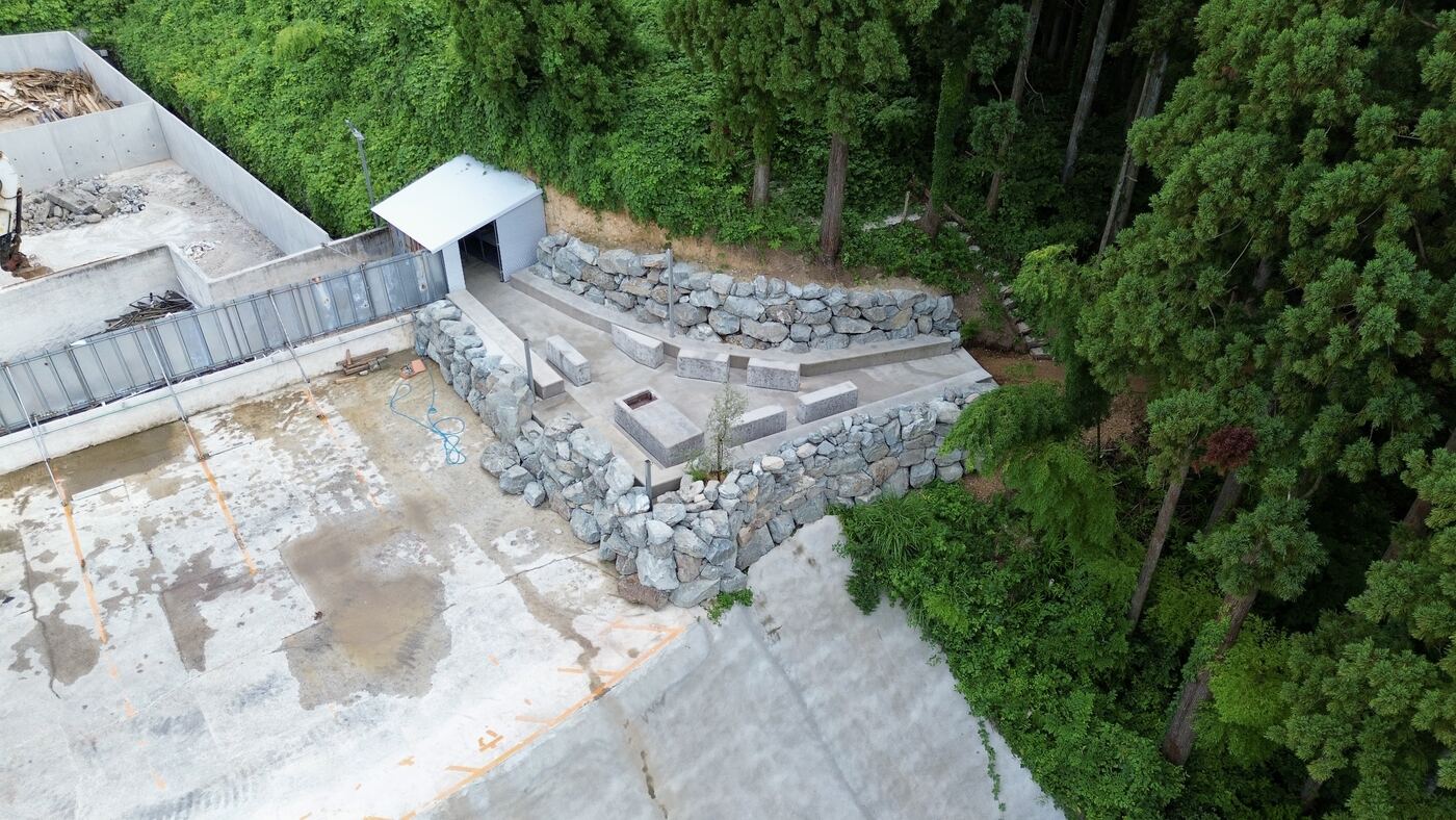 上空から見た杉林と石積みの広場