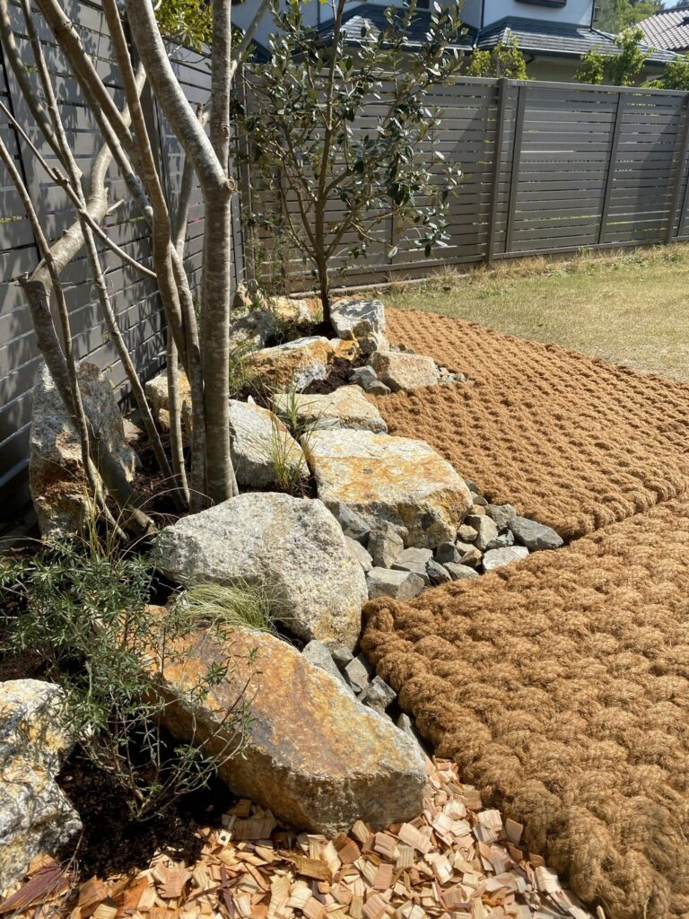 石組みと植栽のきわに沿わせて敷いたココペーバー