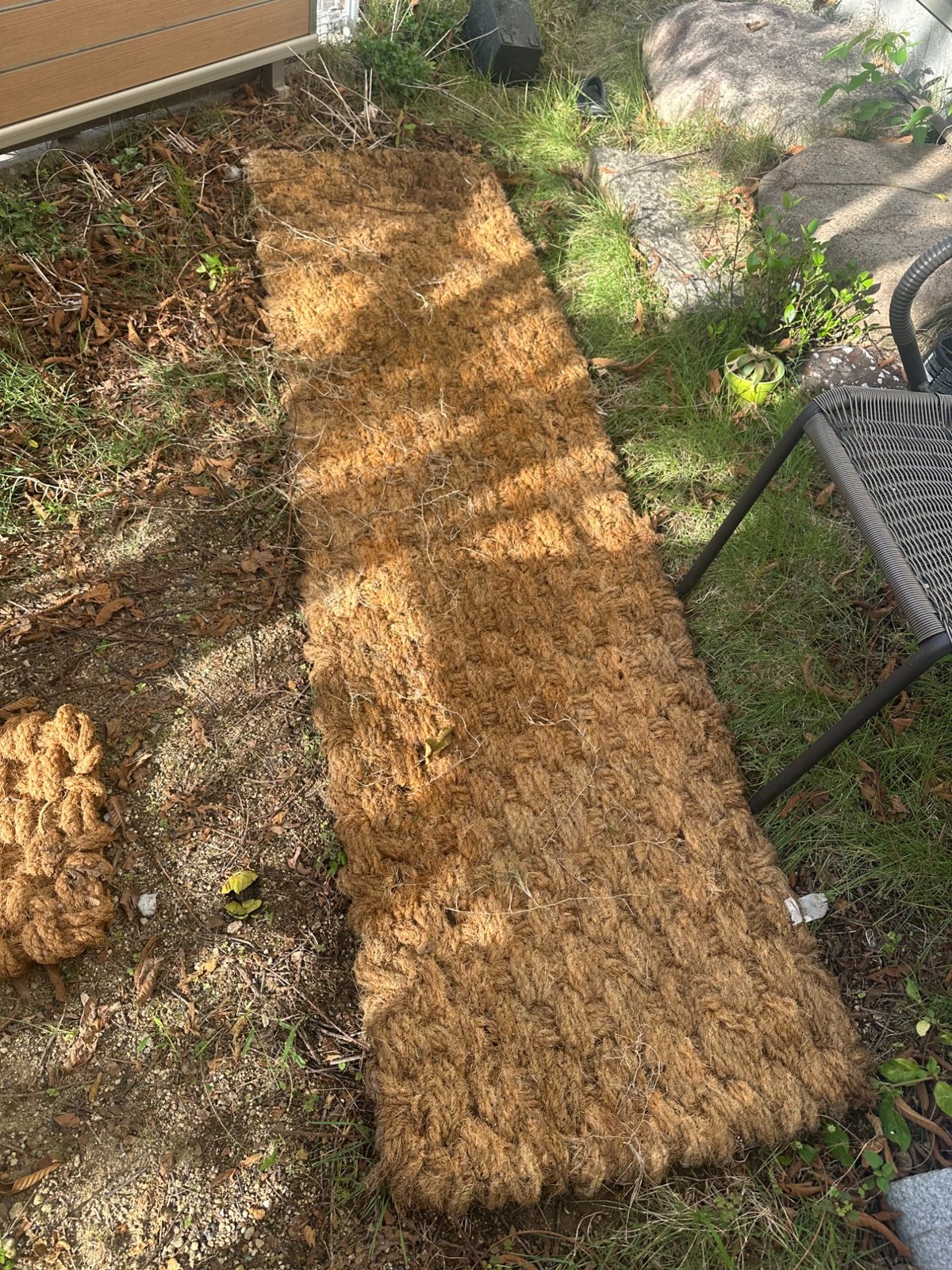 洗った翌朝のココペーバーを別の角度から。編み目がはっきりと見え、隣の芝生や石とよくなじんでいる